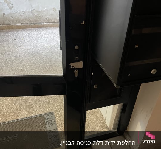 דלת זכוכית שחורה פתוחה עם מנעול ומפתח